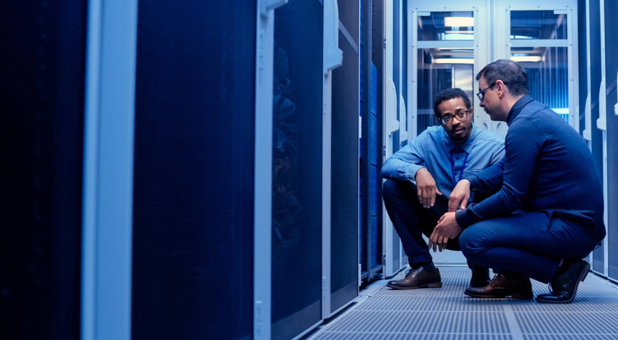 Consulting services two men in server room troubleshooting